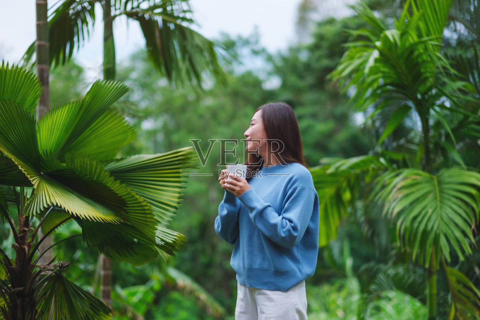一位女性在花园中喝咖啡放松的肖像照片照片摄影图片