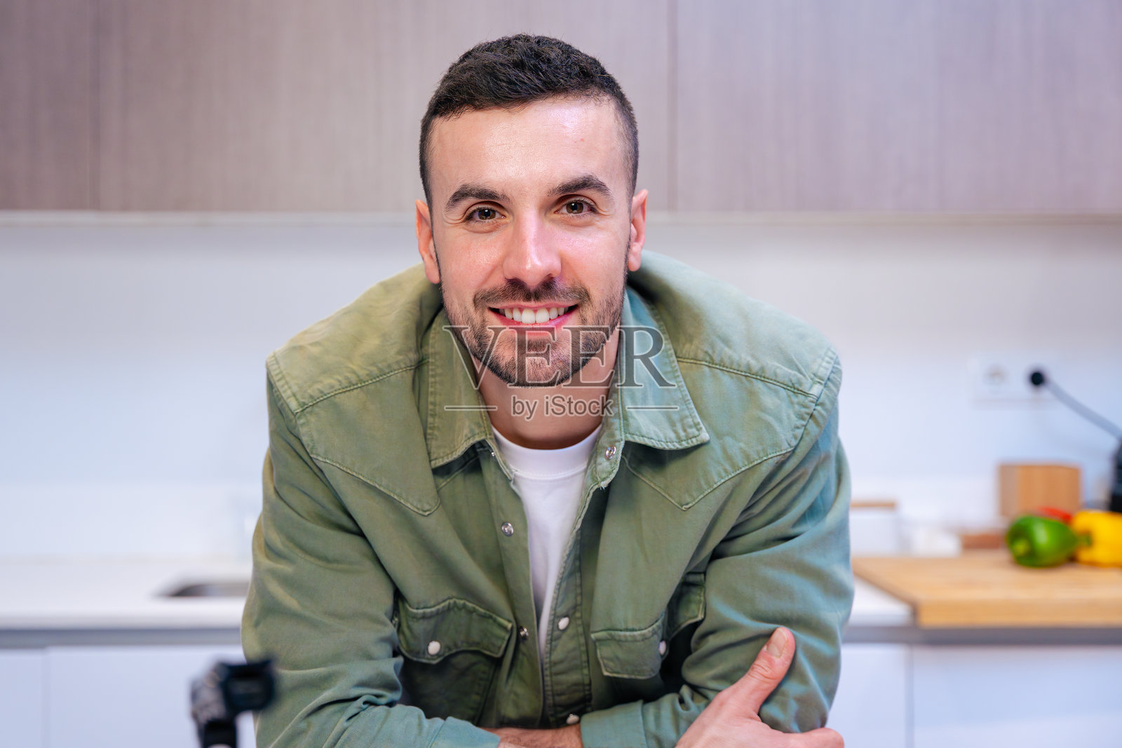 年轻男子在现代厨房内微笑并看向镜头照片摄影图片
