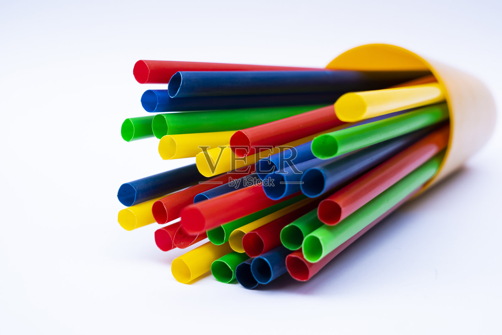 白色背景下容器中的多色塑料饮料吸管特写照片摄影图片