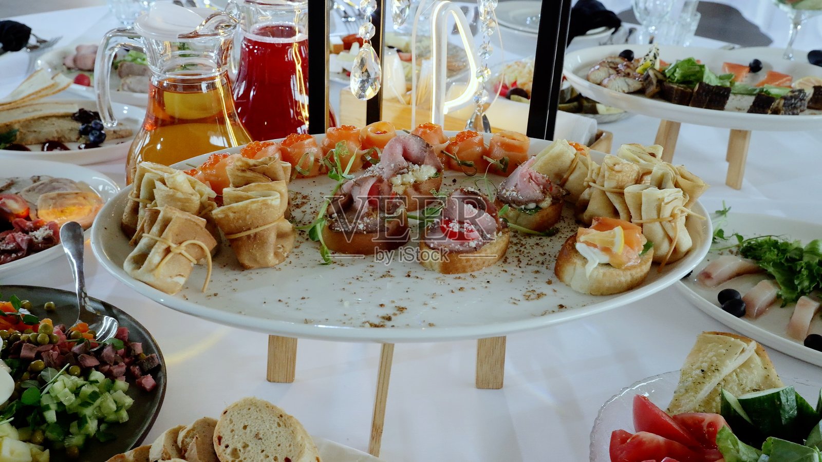 精美的开胃菜拼盘，包含金色煎饼、精致的餐前小吃和各种美食，艺术性地摆放在优雅的桌面上。照片摄影图片