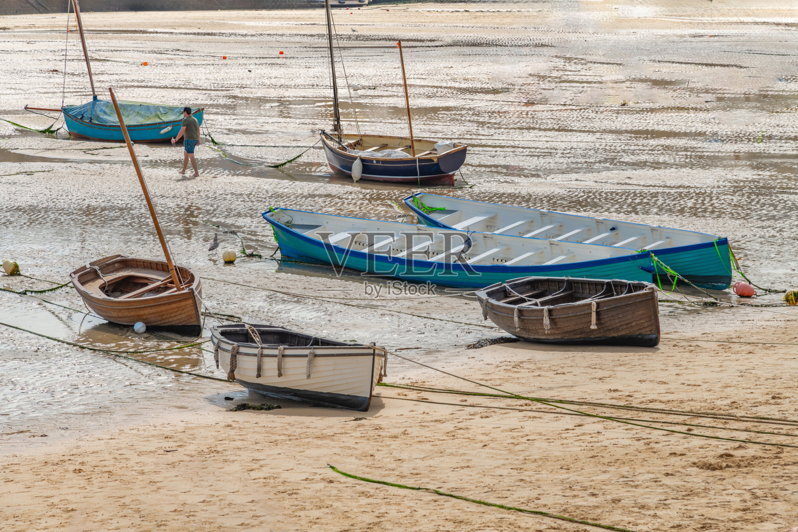 小型彩色船只漂浮在水面上或在退潮时的沙滩上照片摄影图片