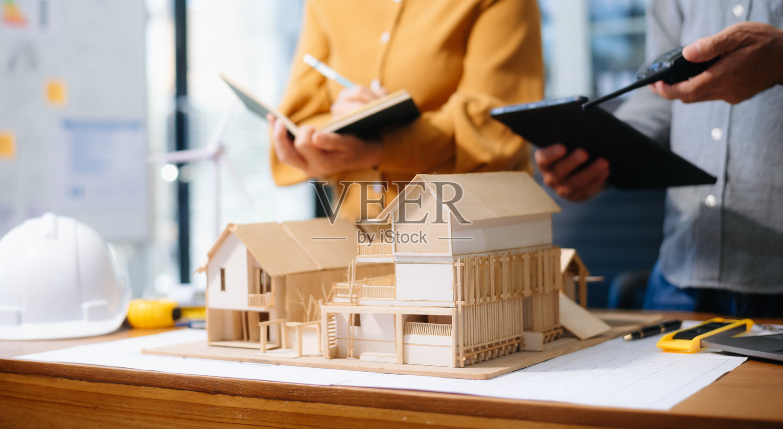 工程师的桌子上有纸张和平板电脑，模糊的工程师团队在努力工作照片摄影图片