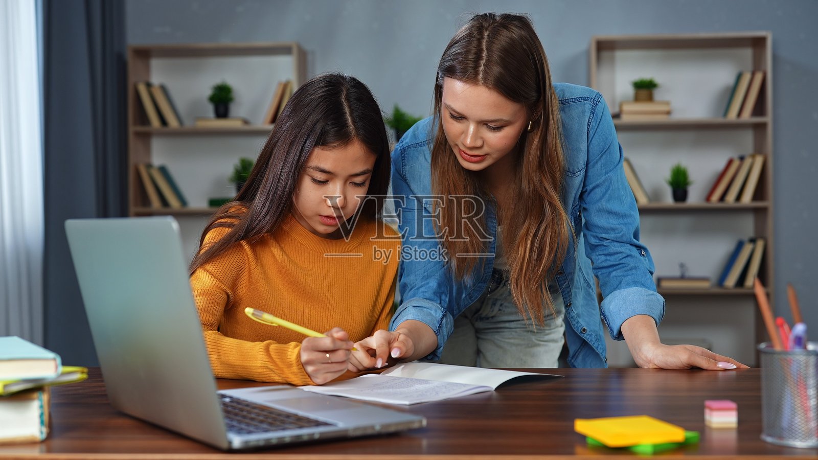 女性和青少年女孩在家中的桌子上一起学习照片摄影图片