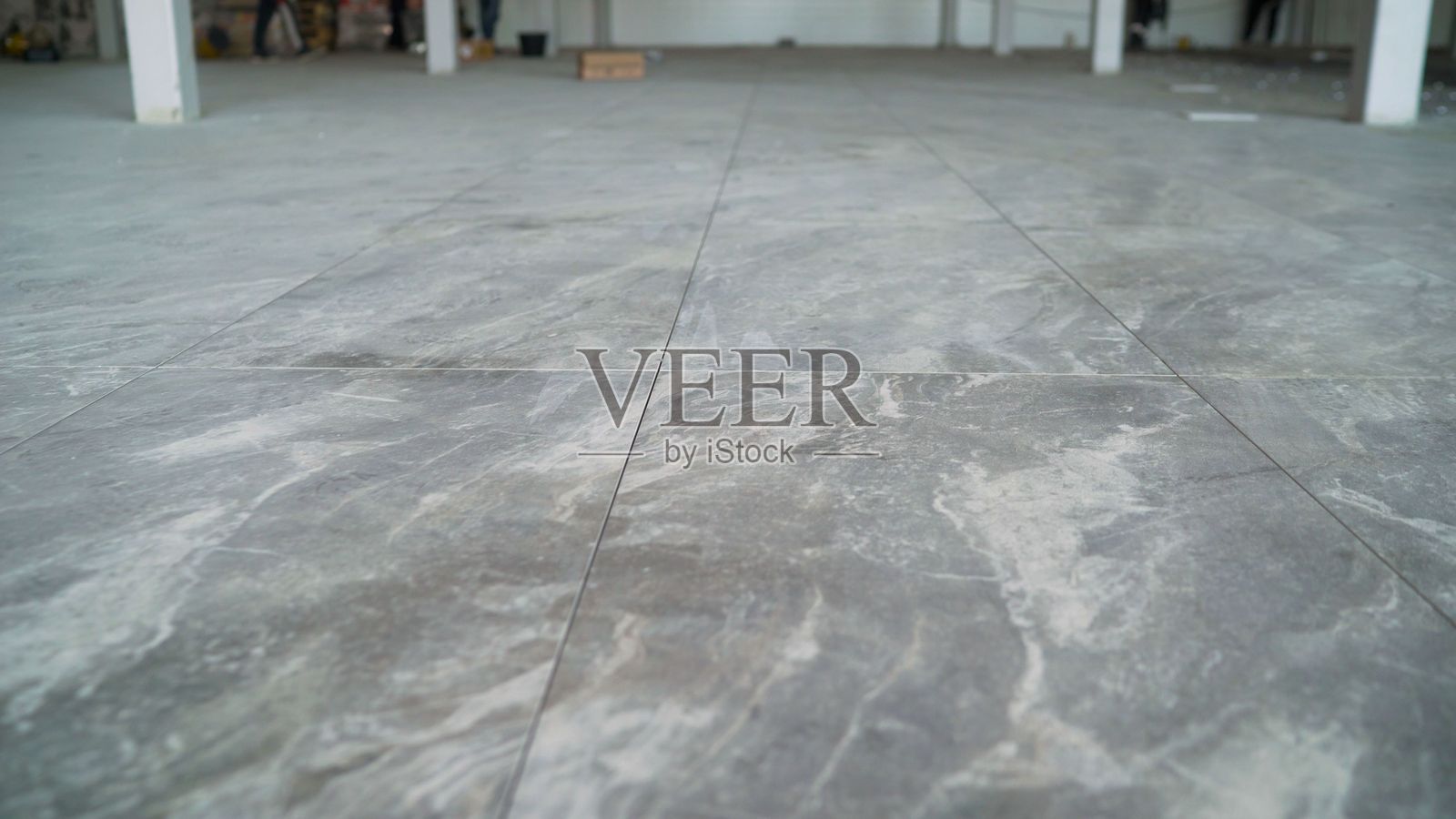 新装修项目，铺设瓷砖地板，大规格陶瓷砖。现代新砖。铺设灰色大规格砖。照片摄影图片