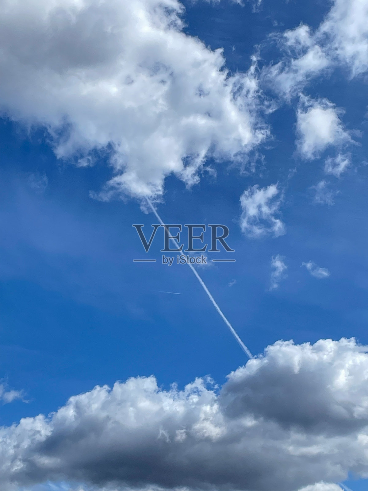 蓝天白云，飞机留下的可见凝结轨迹（航迹云）。照片摄影图片