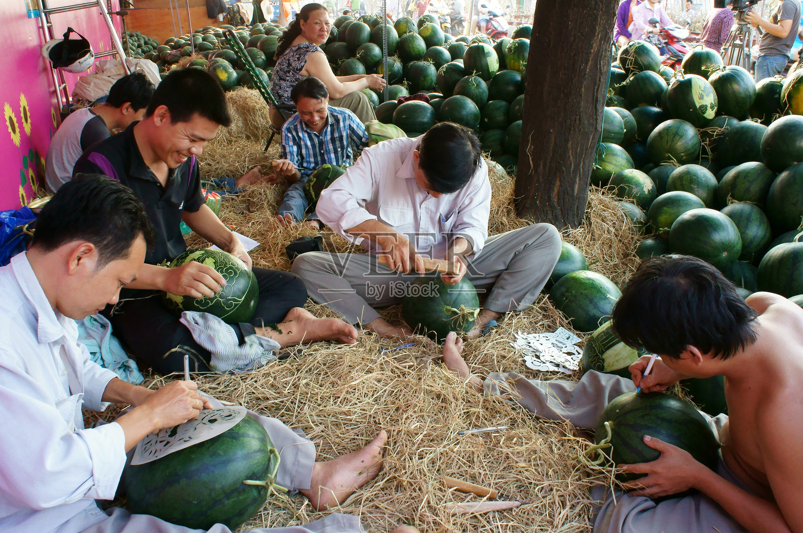 亚洲男子，农贸市场，雕刻西瓜照片摄影图片