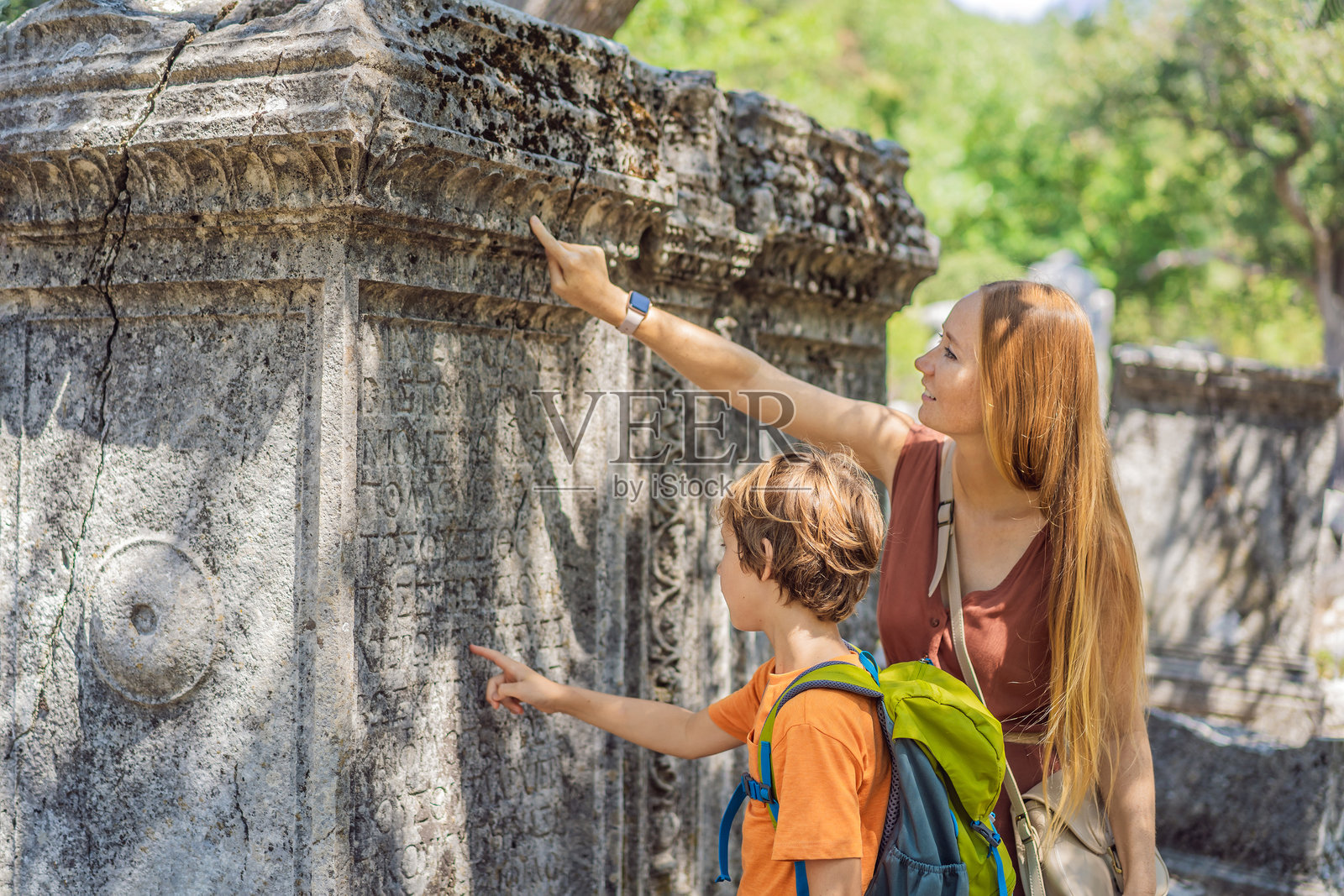 母亲和儿子游客探索特尔梅索斯古城壮观的古剧场。亲子旅行的概念。土耳其，走遍各地。照片摄影图片