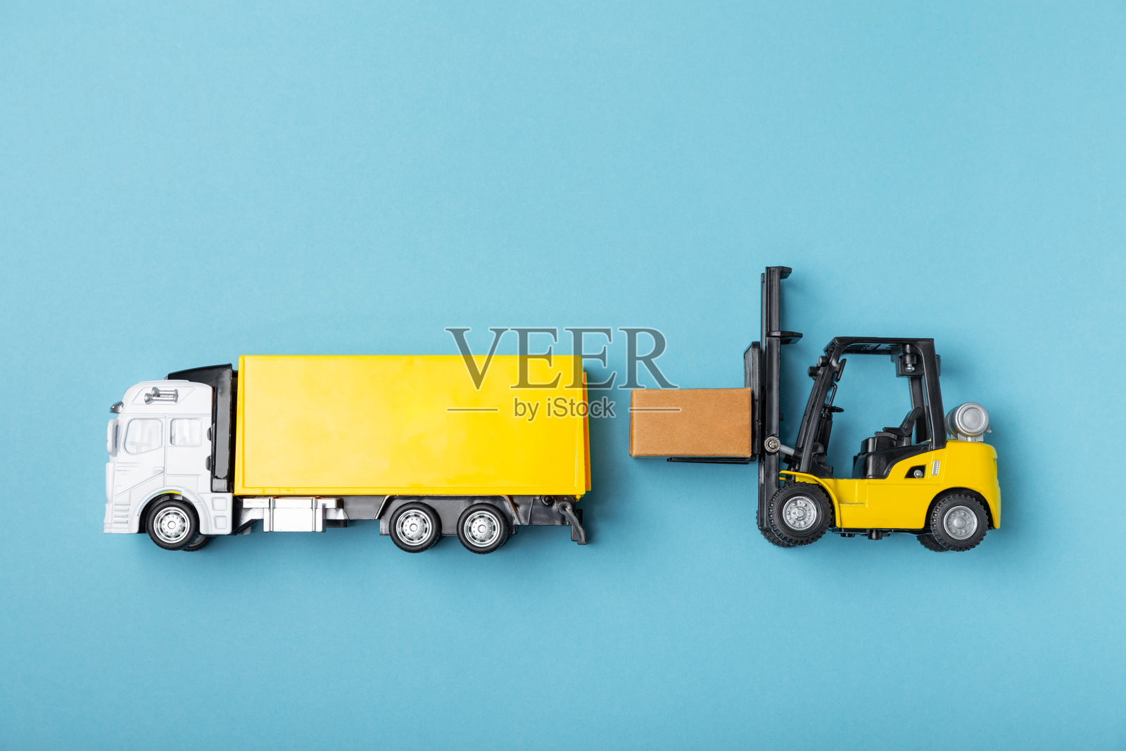 黄色叉车和黄色卡车在明亮的背景下。物流概念。在线购物的物流和供应链管理。商品或产品的全球配送。纸箱。照片摄影图片