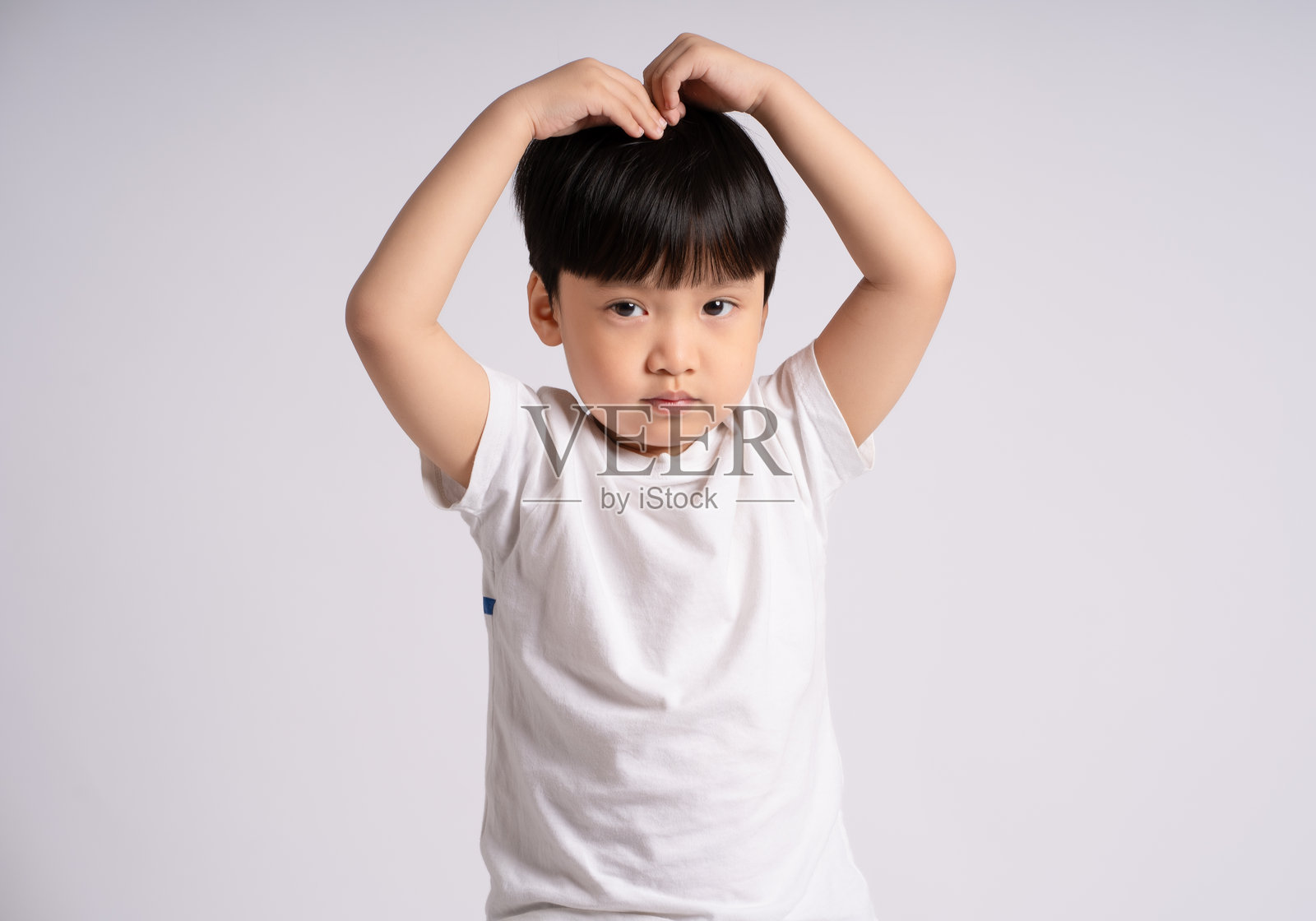 亚洲男孩在白色背景前摆姿势的肖像照片摄影图片