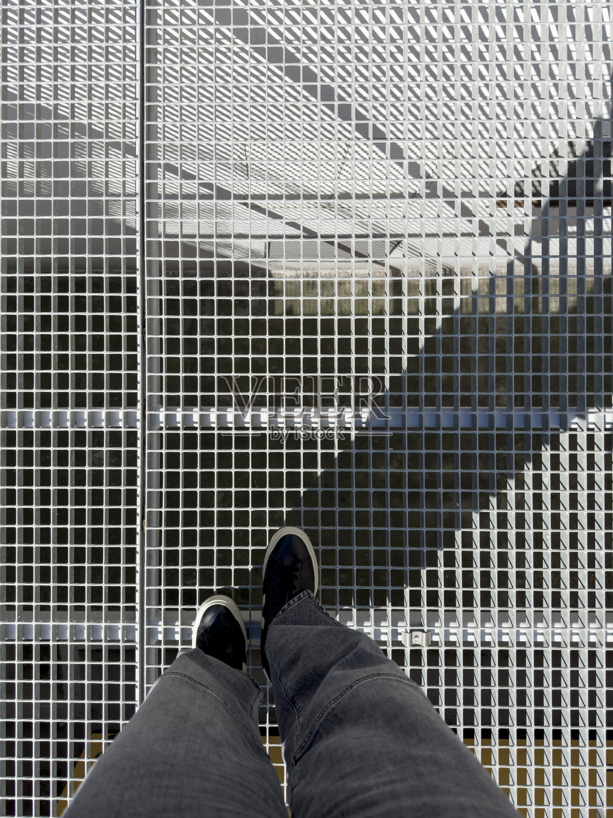 高角度视图下的腿站在金属网格上照片摄影图片