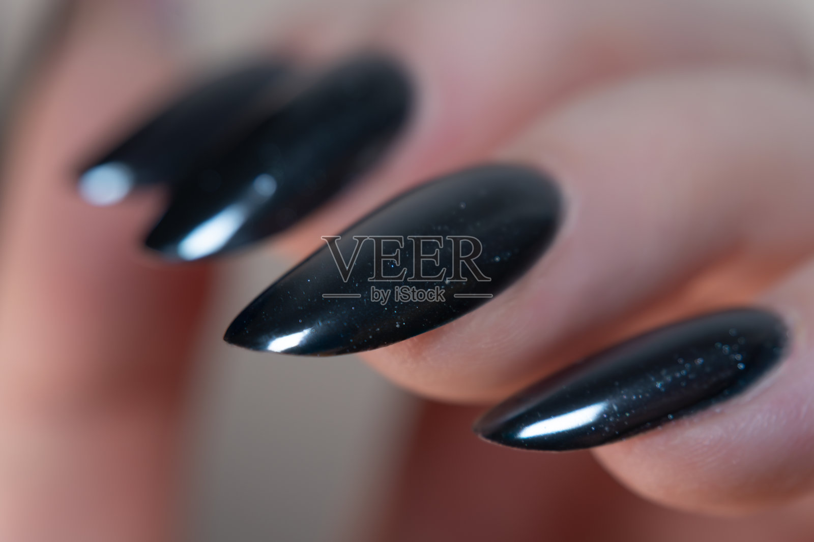 黑色美甲的特写，镜面般的光泽，突显了光滑和精致的效果——优雅与潮流的完美结合。照片摄影图片