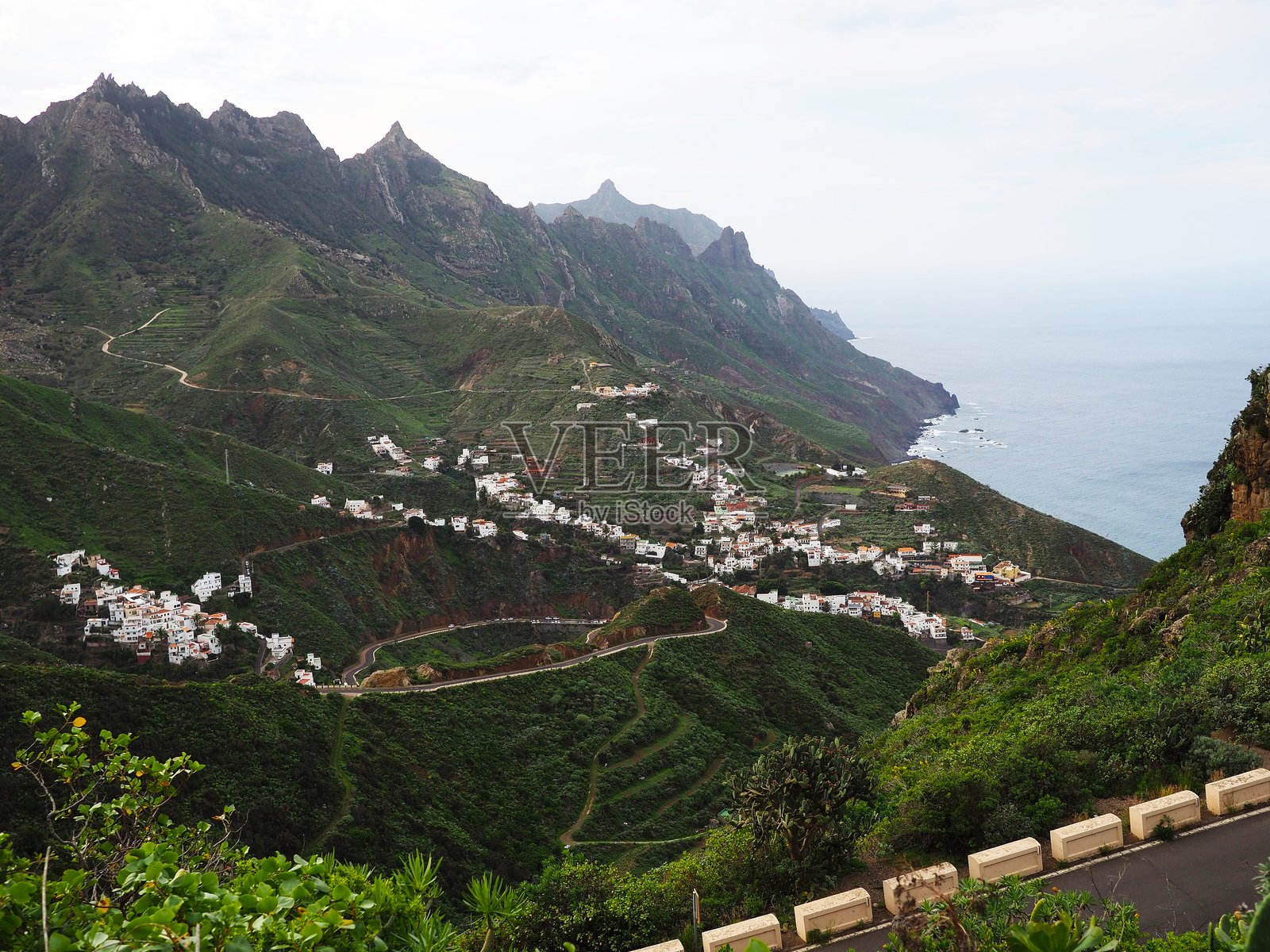 特内里费岛北部的绿色火山坡和悬崖，以及其中的白色村庄。西班牙加那利群岛的风景。照片摄影图片