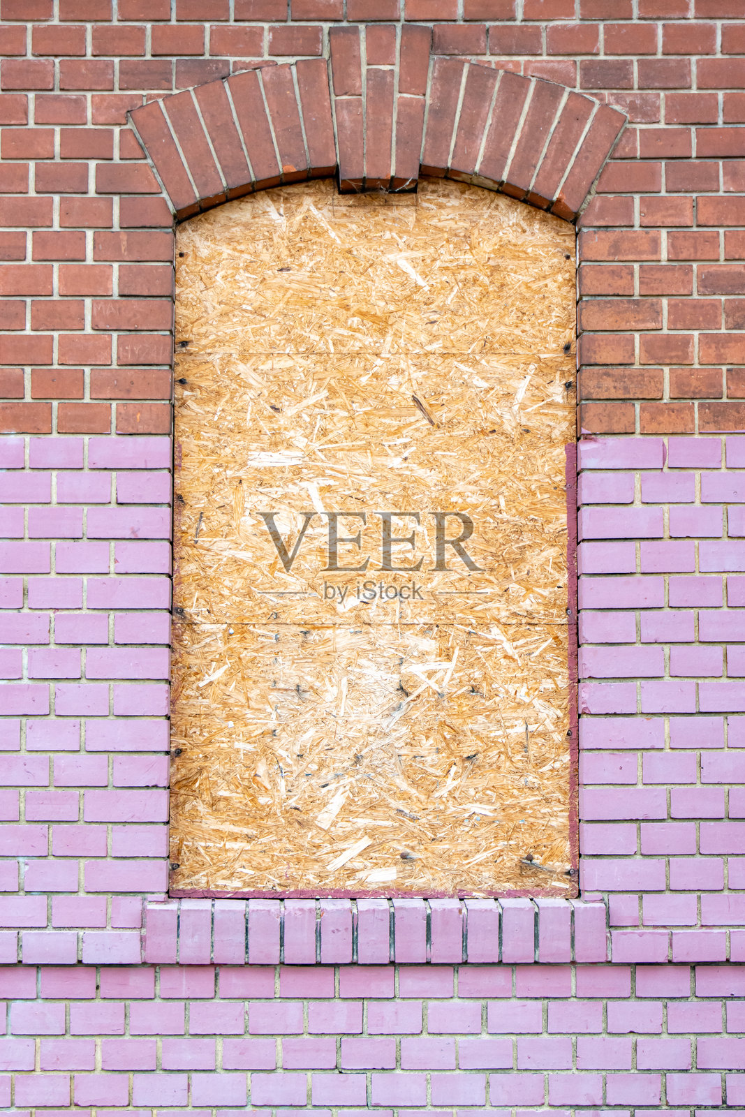 砖砌房屋的外立面，窗户被刨花板封住照片摄影图片