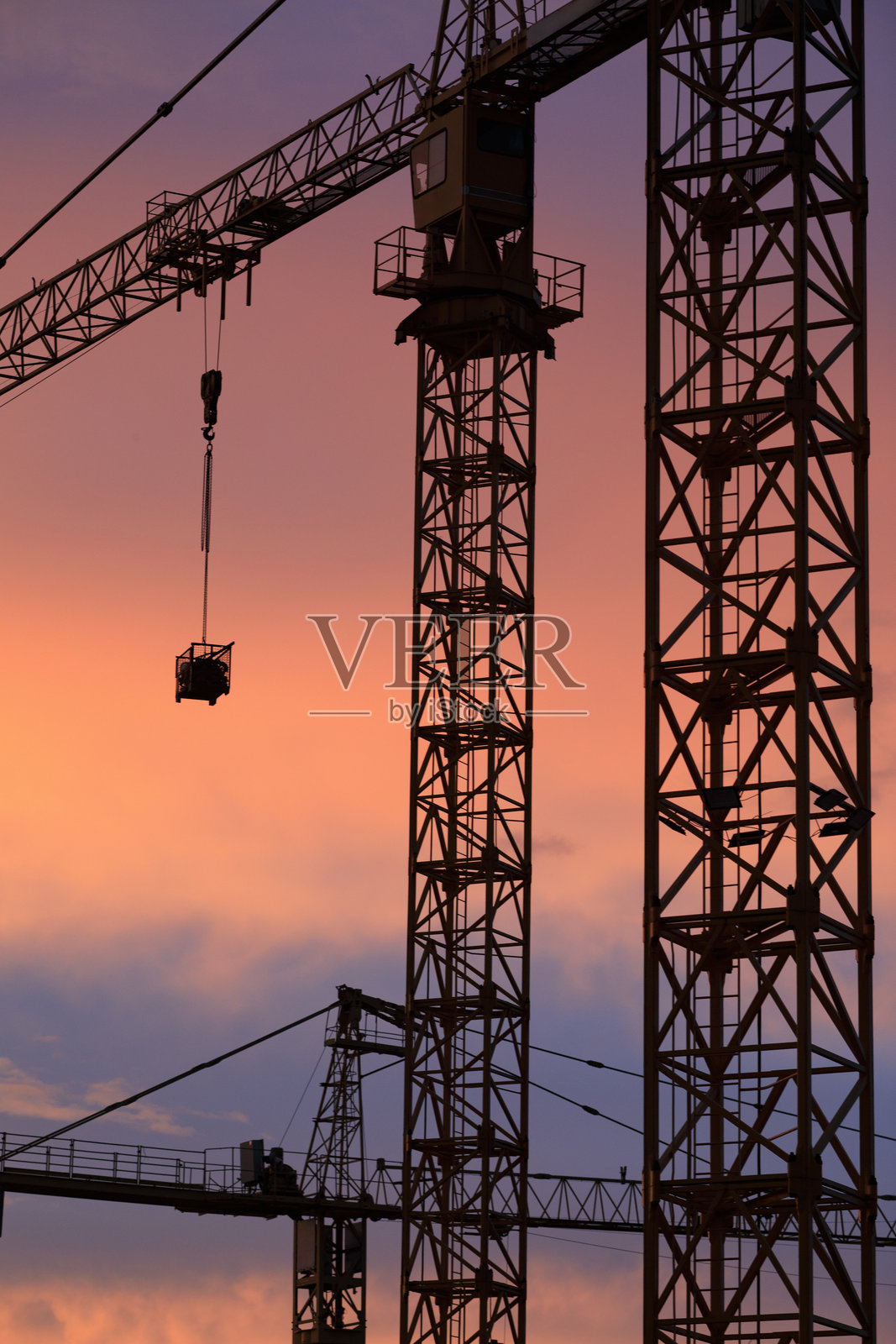 建筑工地上的起重机。日落，色彩斑斓的云彩天空，黄昏。照片摄影图片