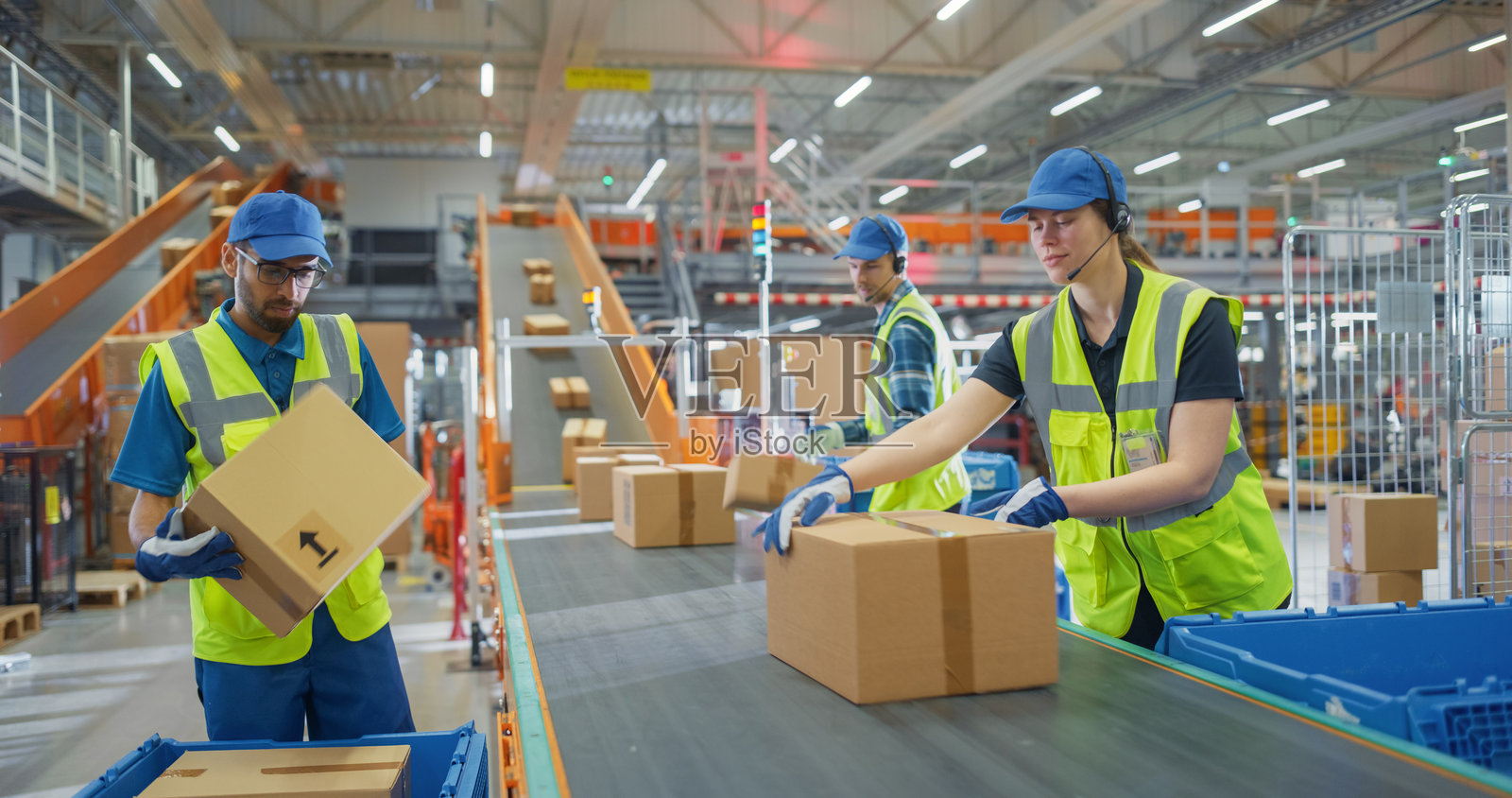 经验丰富和年轻的员工在传送带上分拣包裹和装箱。国家邮政服务设施或现代零售仓库建筑中多元化的员工工作肖像。照片摄影图片