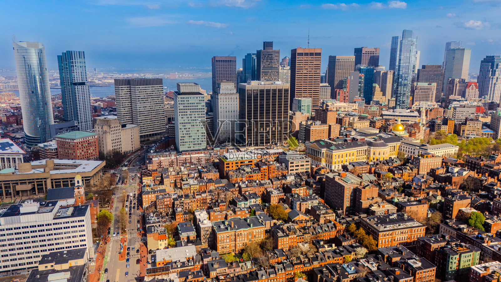 阳光明媚的现代波士顿城市景观，马萨诸塞州，美国。镜头俯瞰老式橙色砖建筑，展现高耸的市中心。照片摄影图片