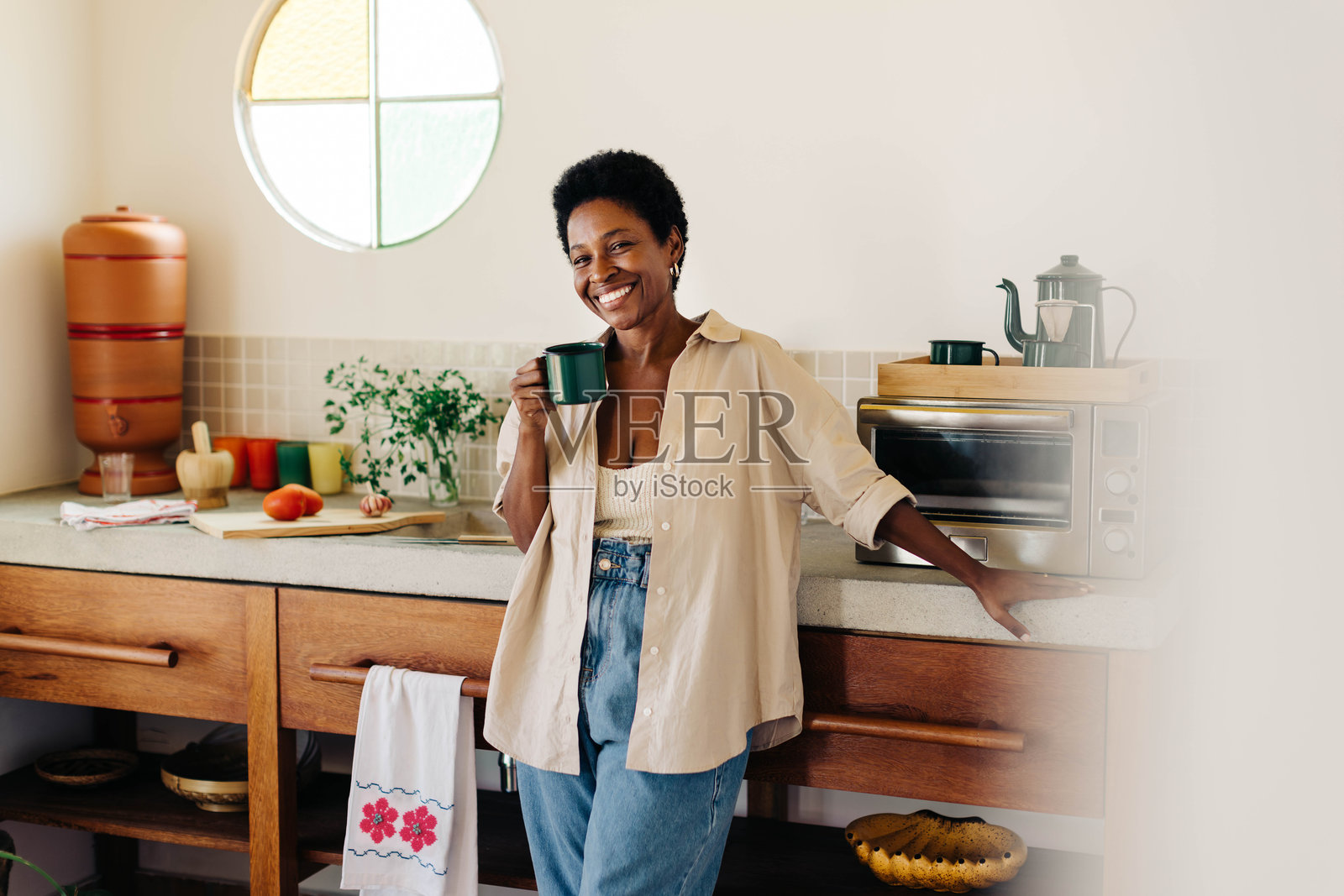 快乐的巴西女性在厨房里微笑着拿着一杯咖啡照片摄影图片