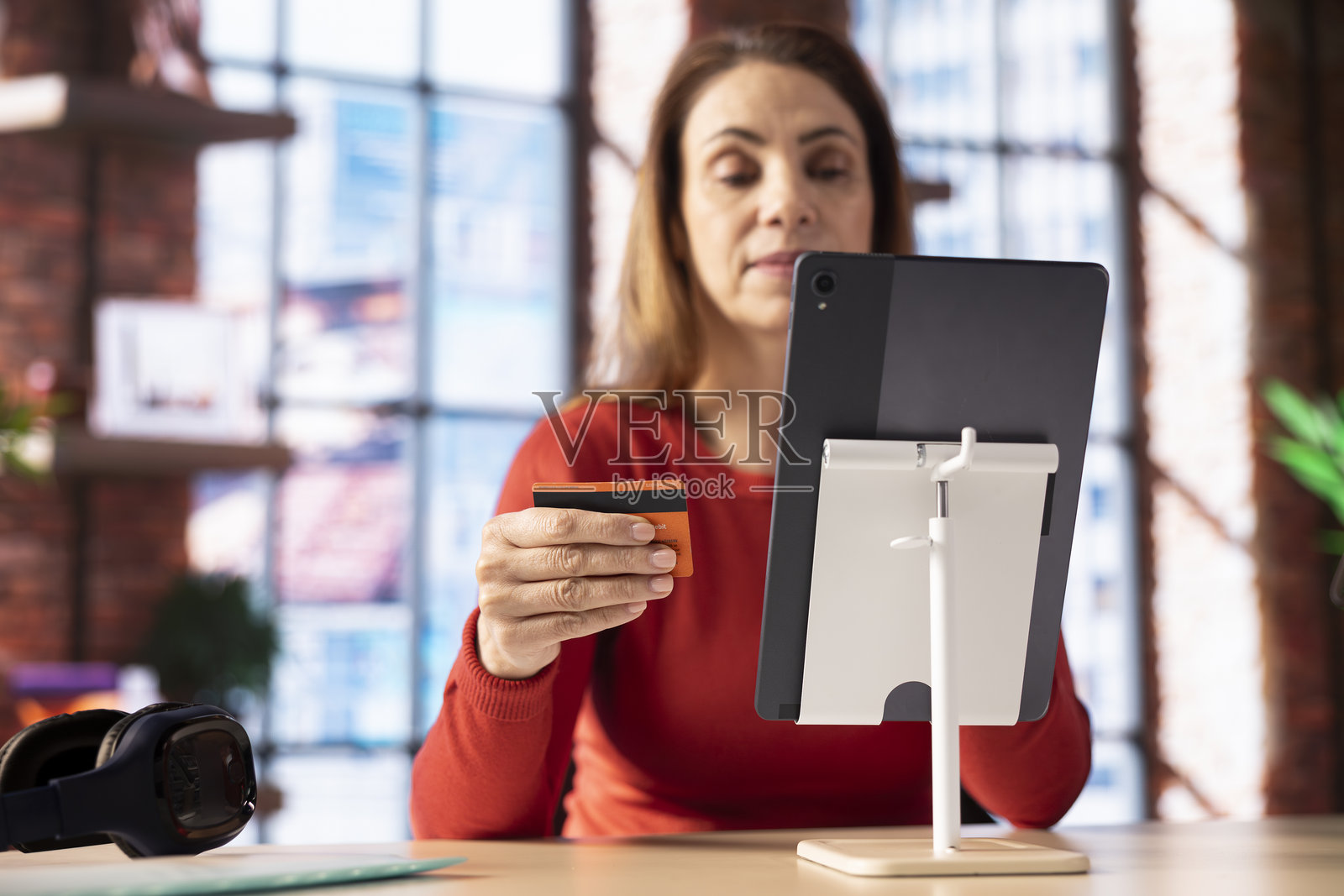 白人女性在家中使用平板电脑在线支付。照片摄影图片