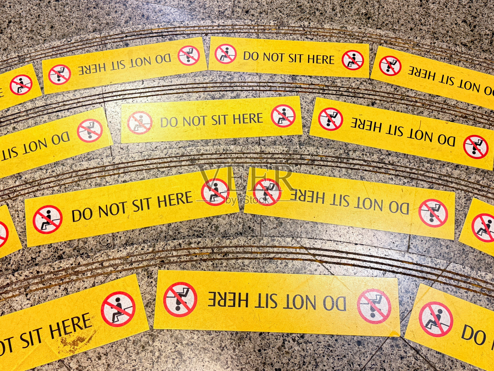 公共场所地面上的“请勿在此处坐下”标志照片摄影图片