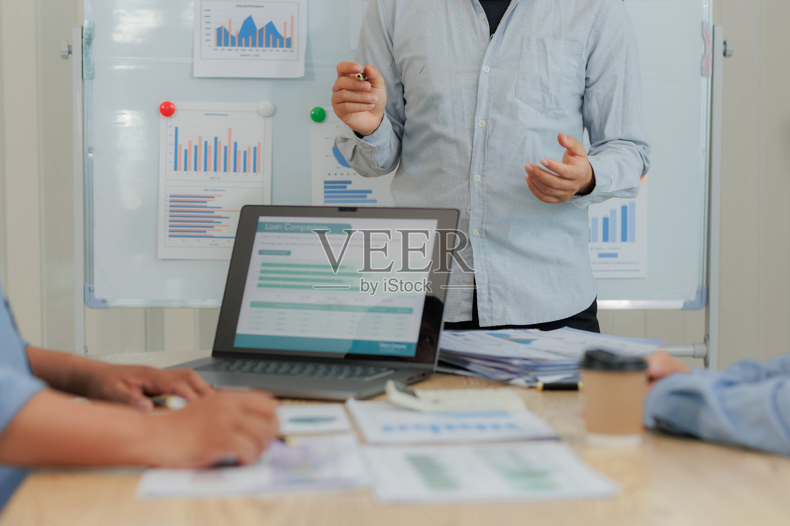 团队使用数字设备审查财务数据和营销计划，强调协作、战略和业务表现。照片摄影图片