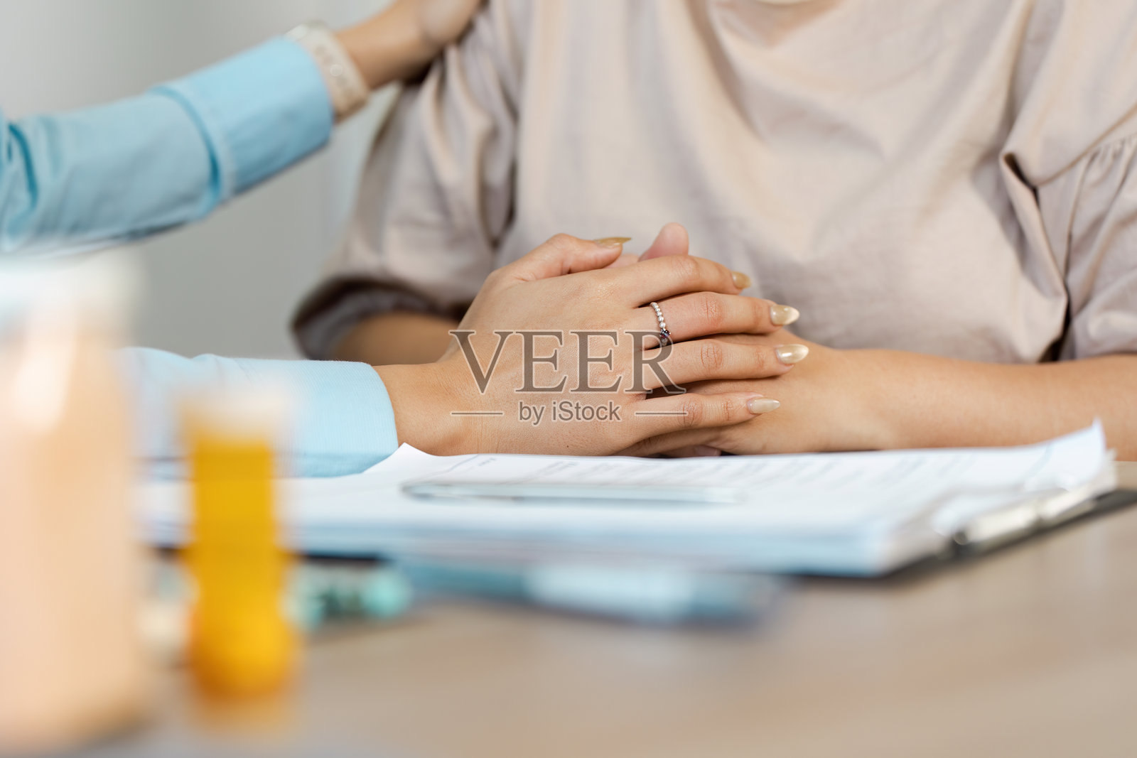 关怀与患者支持。一位医疗专业人员在咨询期间为患者提供情感支持。照片摄影图片