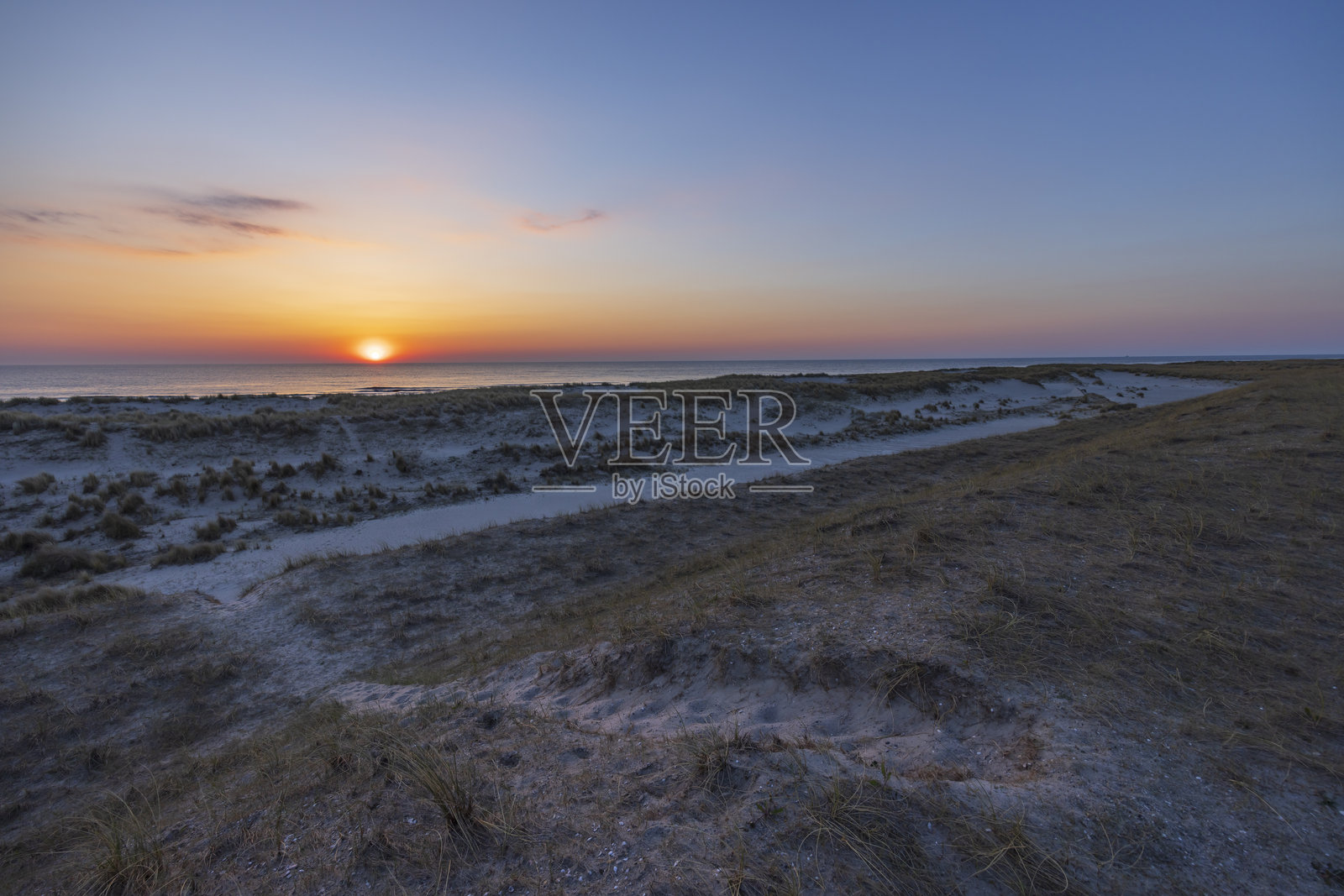 五光十色的日落照亮了荷兰佩滕的沙丘和海滩照片摄影图片