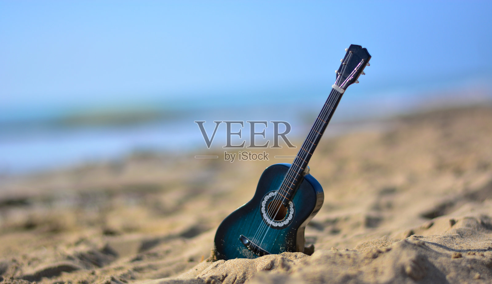沙滩上的吉他，海边音乐会的时代开始了照片摄影图片