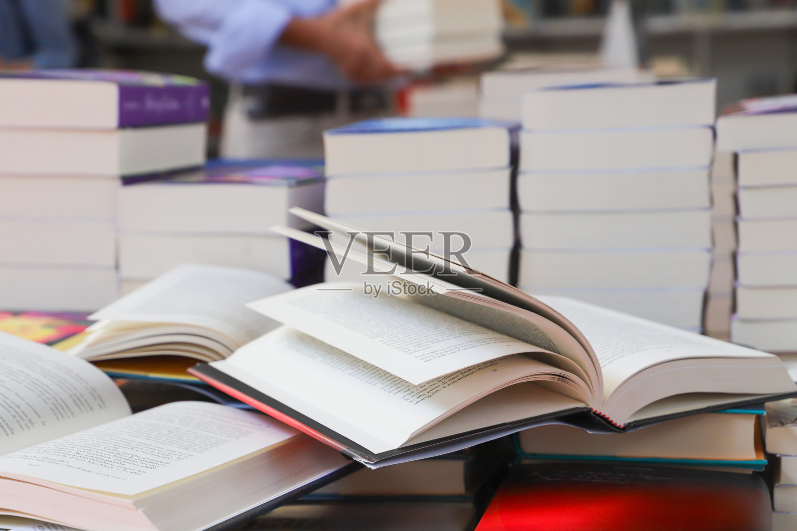 书堆，特写。桌子上的打开书籍，位于图书馆。返校概念。桌子上的打开书籍，模糊的书架背景。照片摄影图片