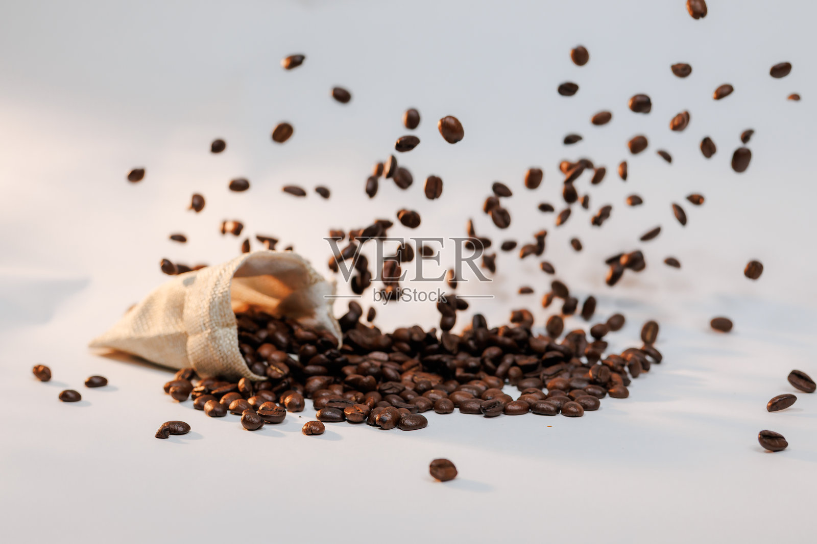 丰富的深烘焙咖啡豆安静地躺在质朴的麻袋中，新鲜且随时可以享用。照片摄影图片