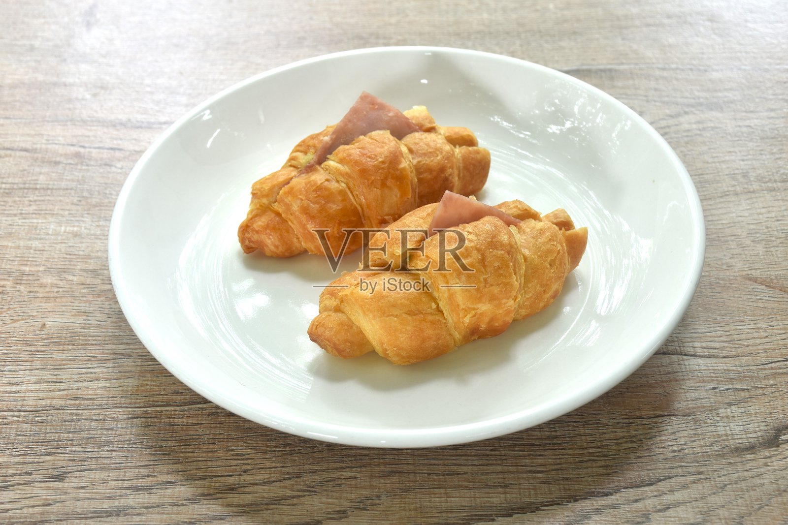 烘焙酥脆的黄油可颂法式面包，夹有火腿、奶酪和菠菜照片摄影图片