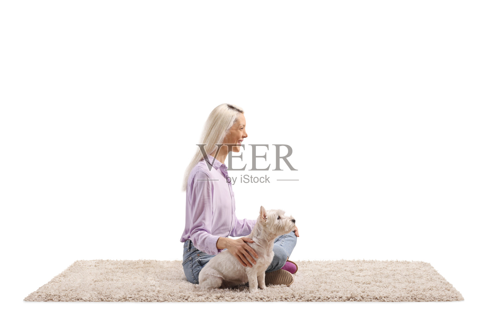 女人坐在地毯上，身边有一只西高地白 Terrier 狗照片摄影图片