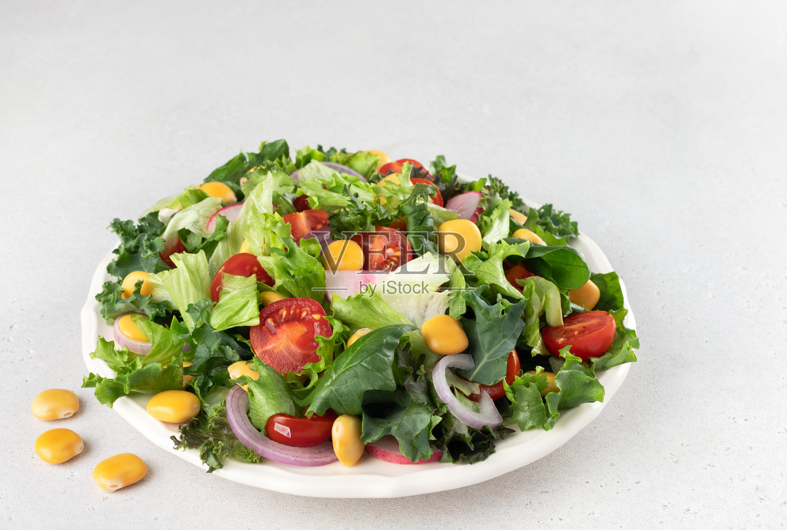 白色背景上的新鲜蔬菜和羽扇豆的绿色沙拉。素食食品。照片摄影图片
