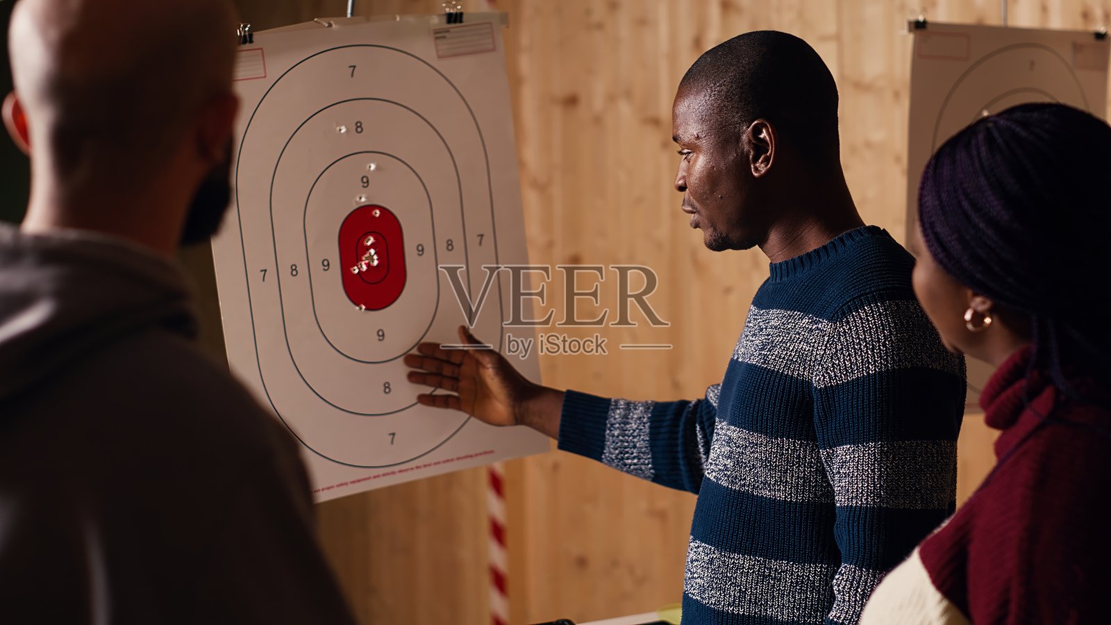 射击场安全官向人们解释靶心得分系统照片摄影图片