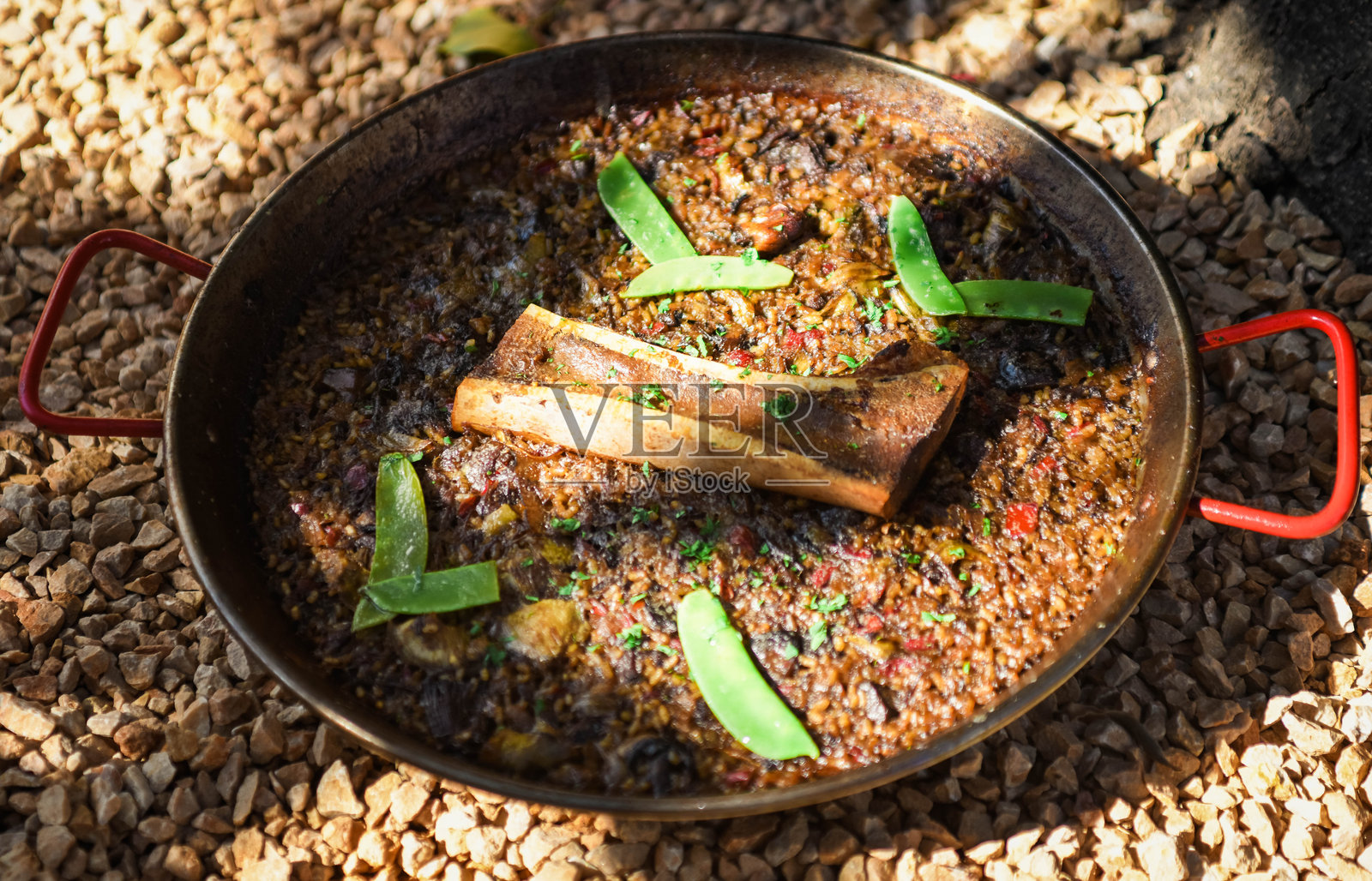 美味的西班牙海鲜饭配骨髓和雪 peas照片摄影图片