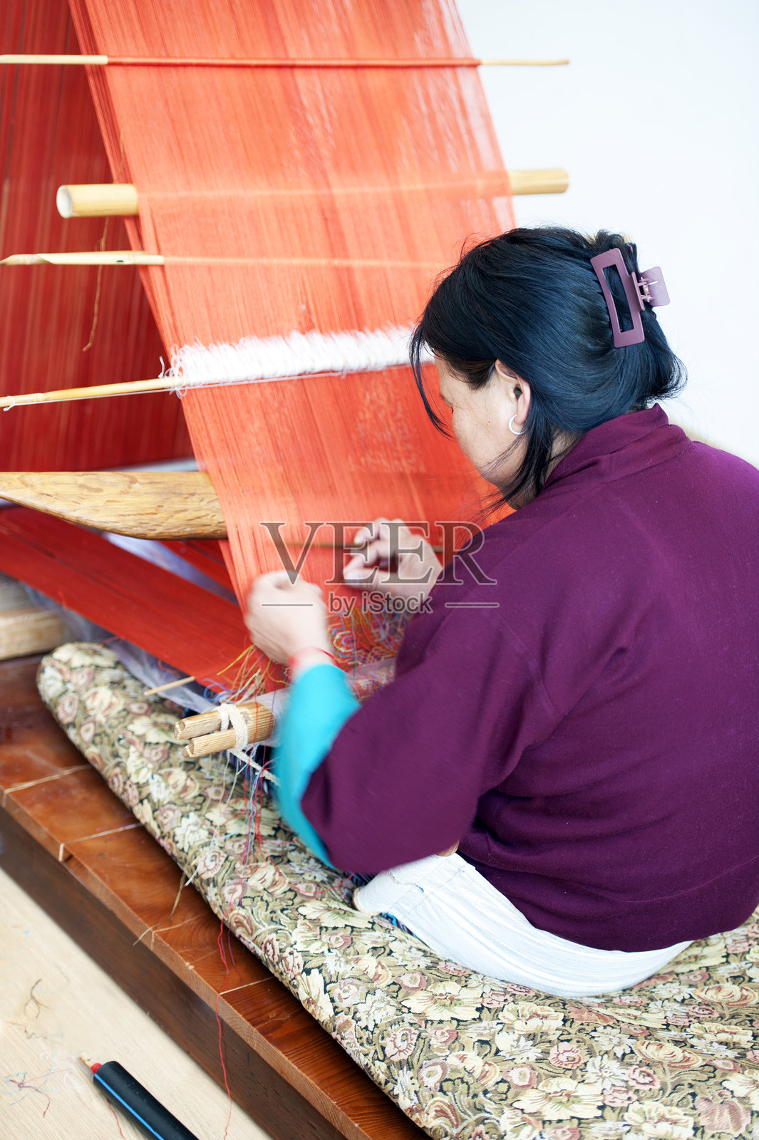 一位女性在不丹廷布的手织机上编织精美图案的羊毛材料照片摄影图片