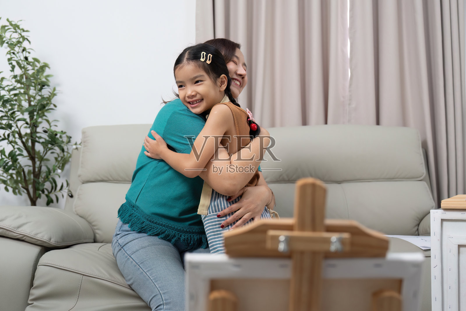 母女在舒适的室内环境中热爱活动地拥抱在一起照片摄影图片
