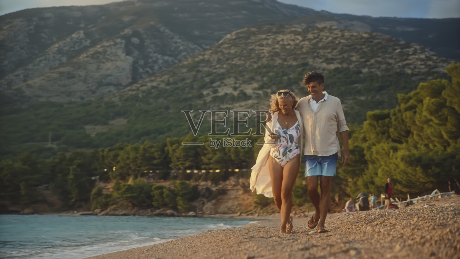 的白人夫妇在金色日落时分漫步于扎尔特尼拉特海滩照片摄影图片