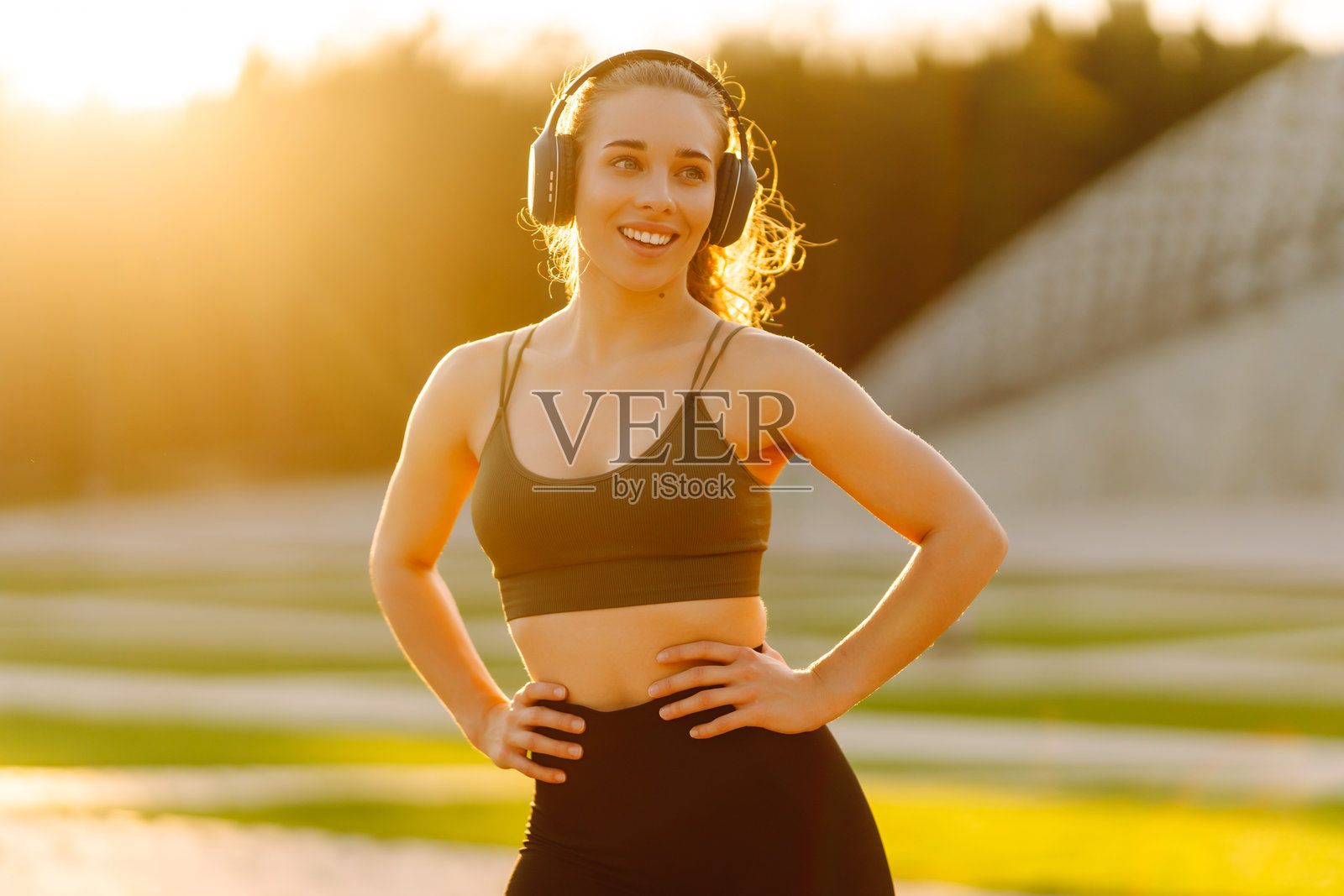 美丽的女性穿着运动服在日落时分热身准备锻炼。照片摄影图片