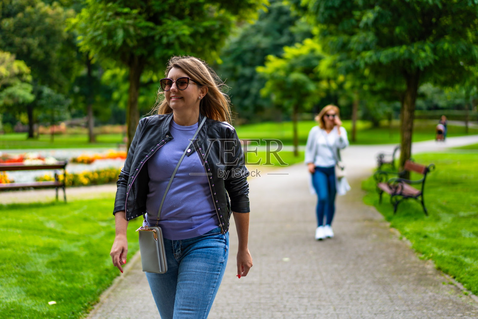 两位快乐的女性在城市公园散步。朋友的相聚。在公园散步。照片摄影图片