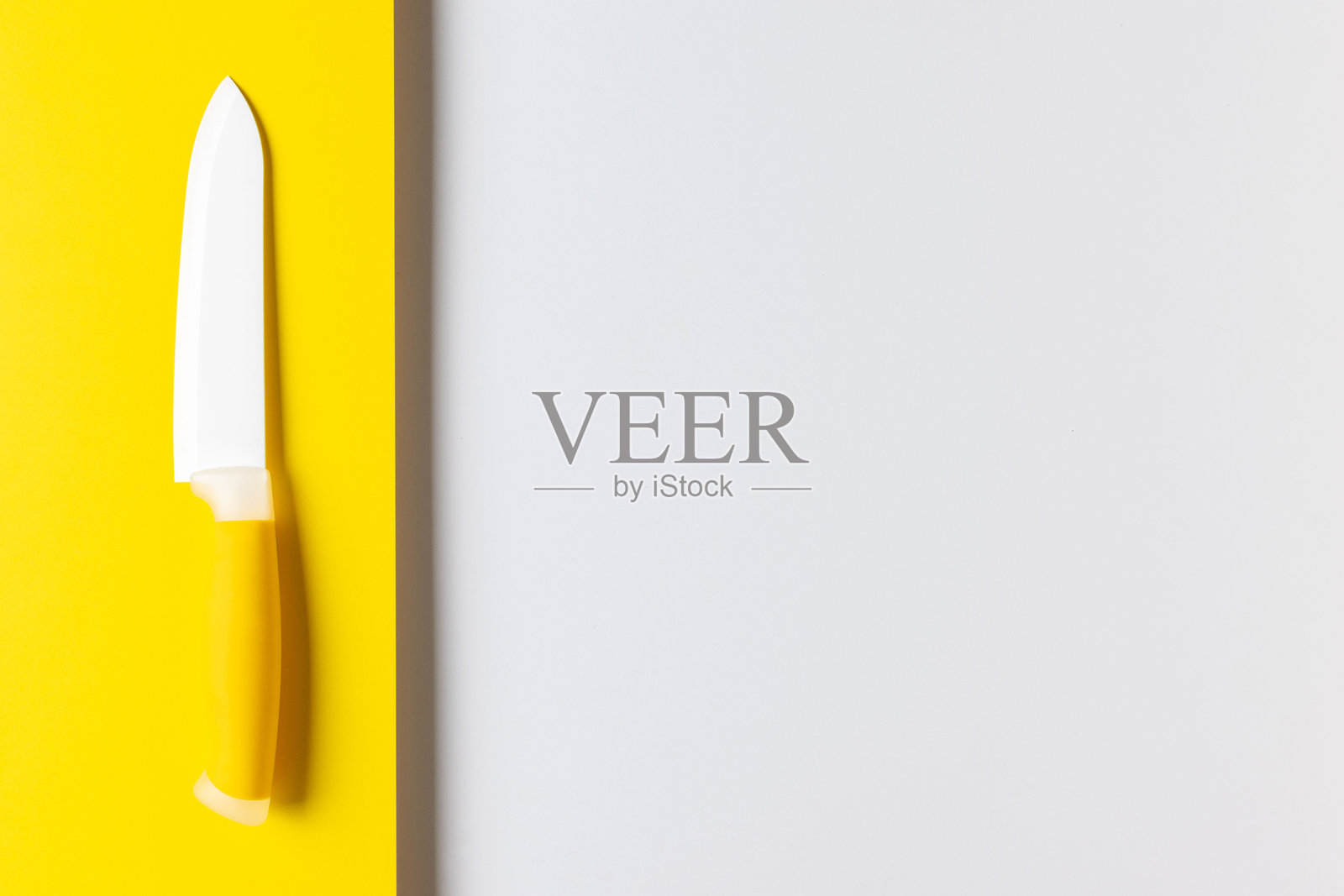 极简主义的黄色和白色陶瓷刀置于现代双色背景上照片摄影图片