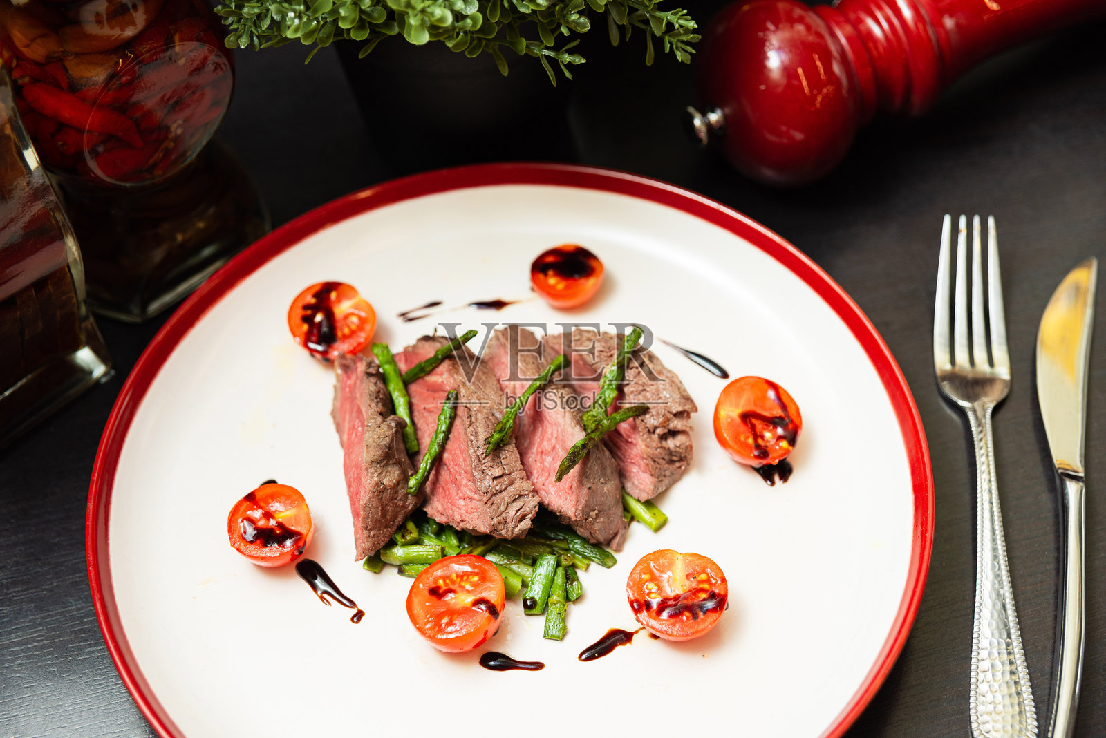 中等偏生的牛排配樱桃番茄和酱汁。照片摄影图片