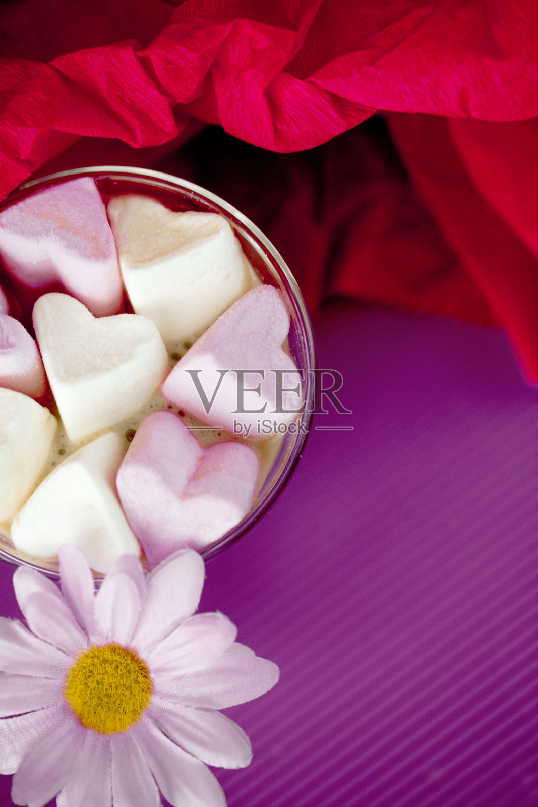 紫色背景上的情人节心形棉花糖和咖啡杯中的雏菊 – 甜美的平铺图照片摄影图片
