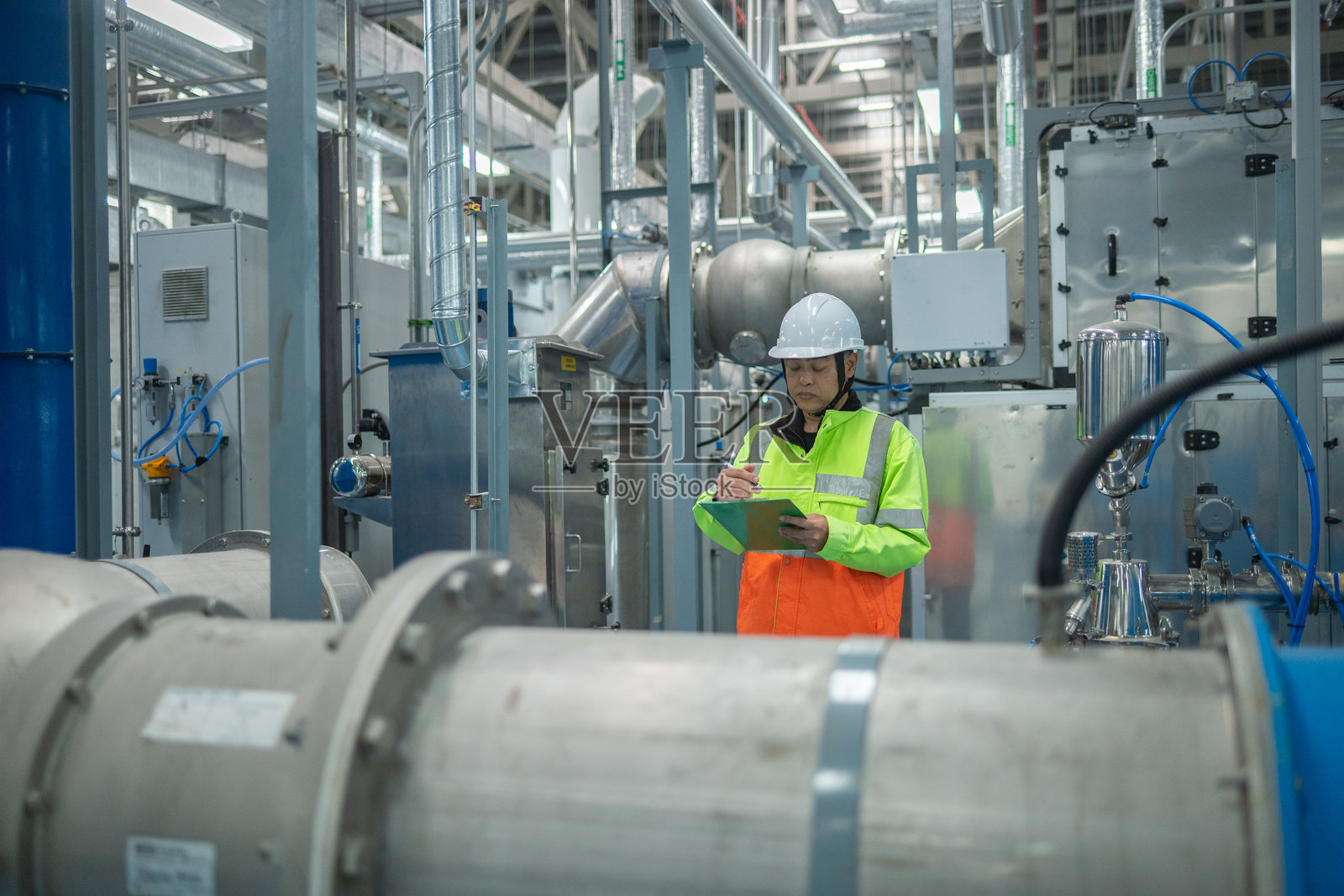 工程师或工人在工业设施的操作系统中进行检查和维护，包括暖通空调（HVAC）、化学加工或清洁能源自动化工业环境。照片摄影图片