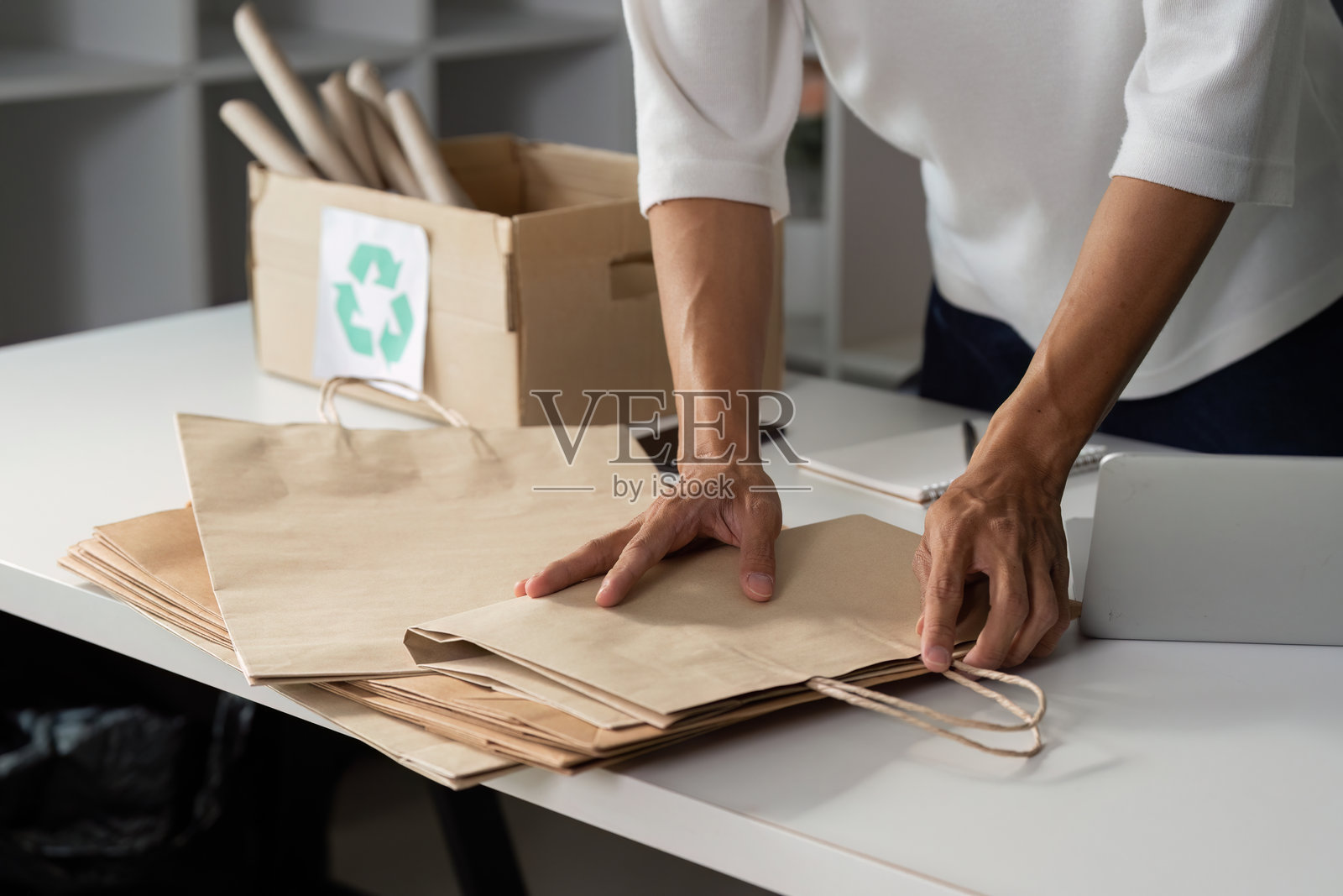 个人整理纸袋以便回收，倡导日常生活中的可持续实践。照片摄影图片