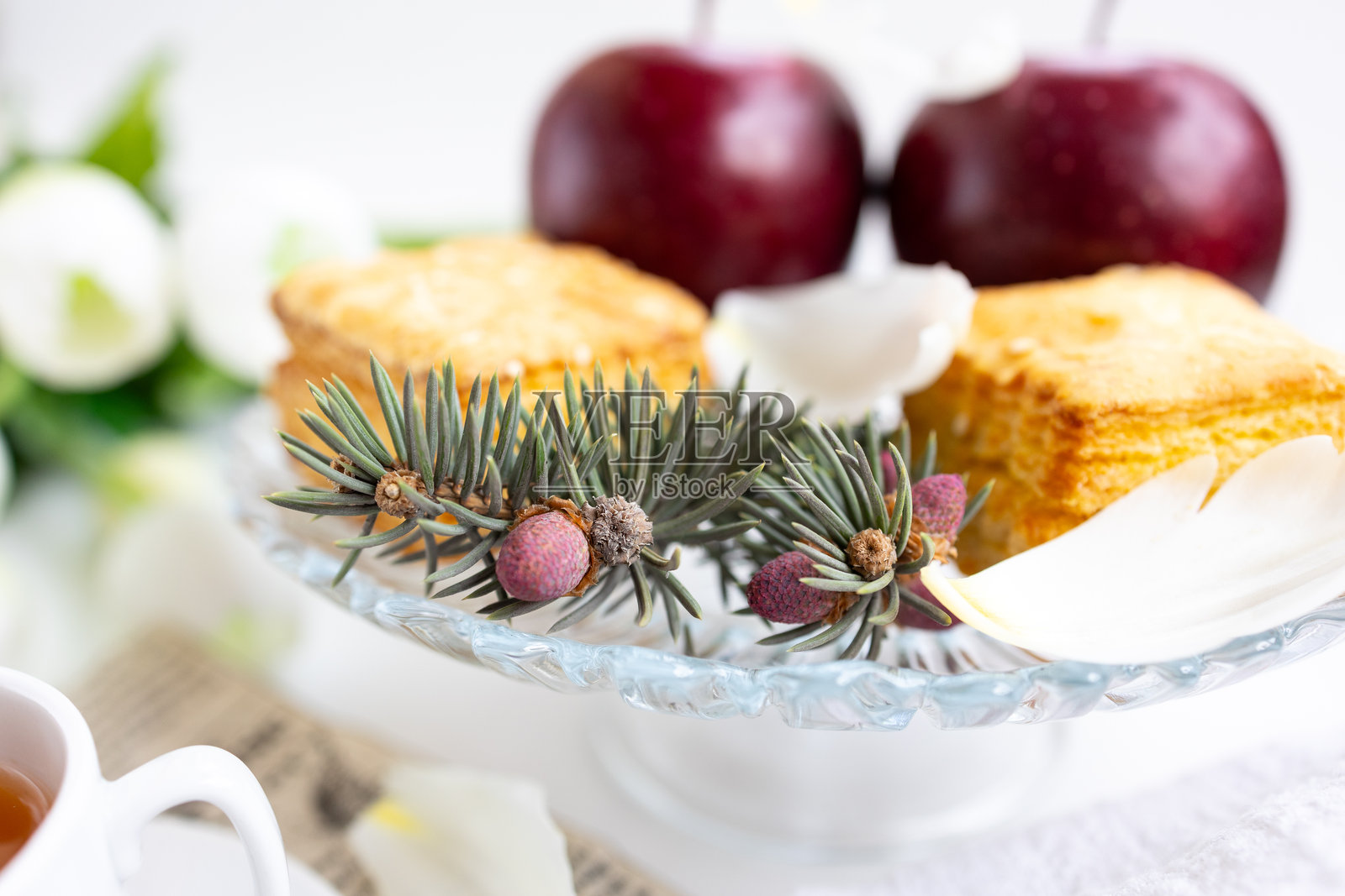 桌子上有一杯茶、一些蛋糕和一束花照片摄影图片