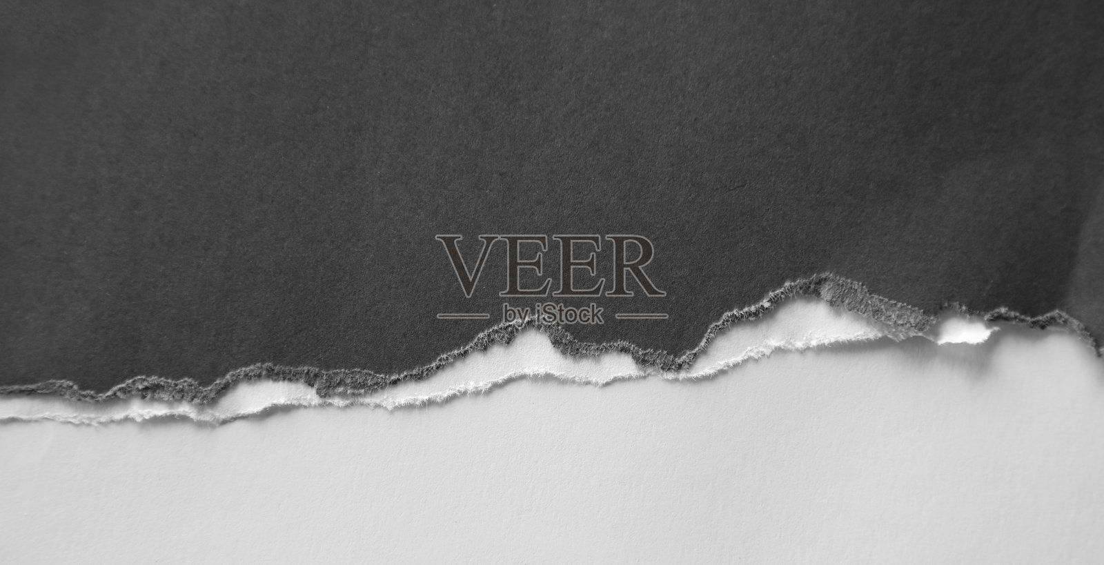撕裂的灰色纸张上的缝隙照片摄影图片