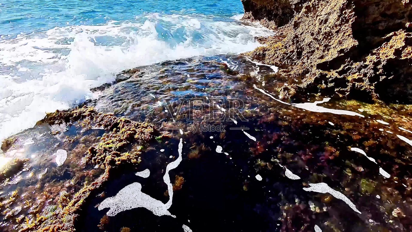 体验宁静的海岸岩池，伴随着海浪和美丽的泡沫照片摄影图片
