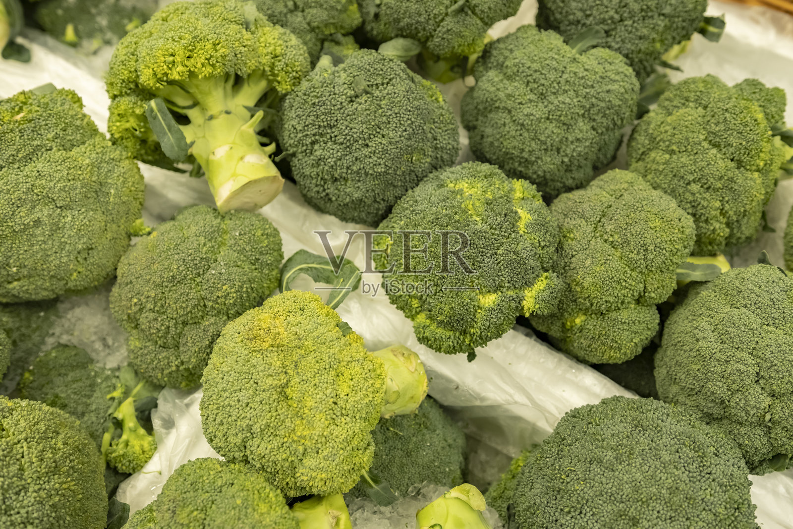 绿色西兰花在蔬菜柜台上的特写。照片摄影图片