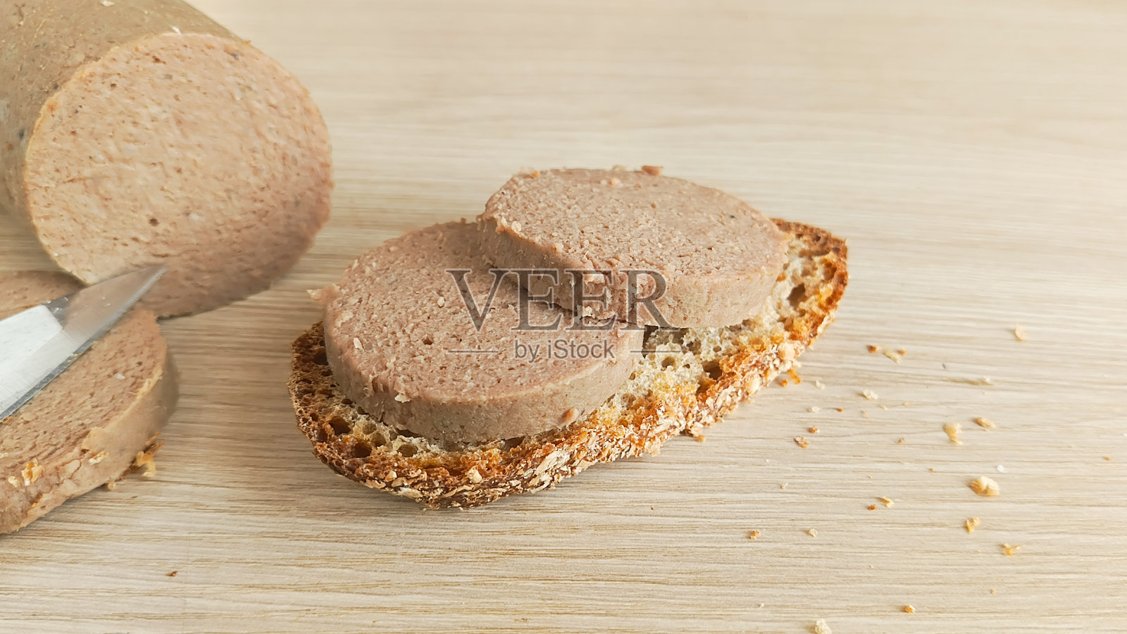 桌子上的肝肠三明治。由内脏制成的肝酱香肠。一片肝肠。照片摄影图片