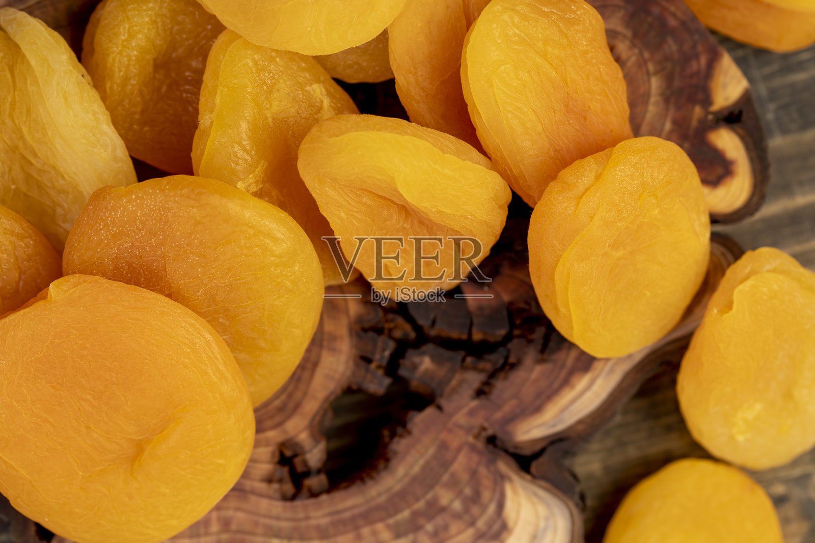 许多干杏干在去除种子后脱水，杏子放在木板上，特写镜头。照片摄影图片